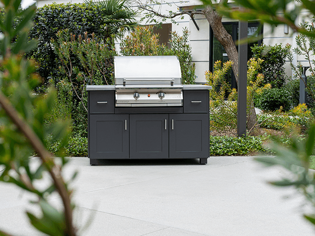 pgs grill in a black cabinet on a tidy outdoor patio